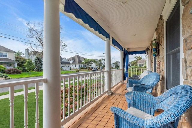 deck featuring covered porch and a residential view