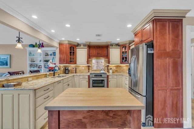kitchen featuring a peninsula, glass insert cabinets, a sink, stainless steel appliances, and visible vents