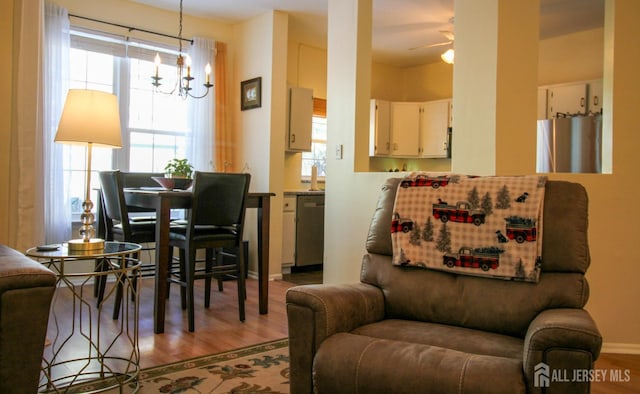 interior space with wood finished floors and ceiling fan with notable chandelier