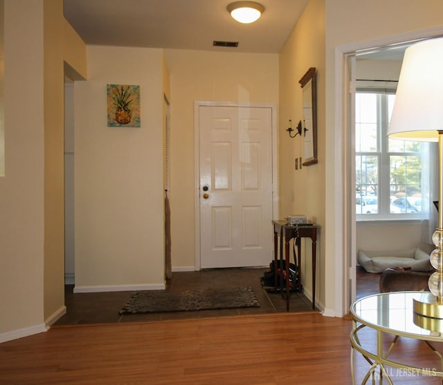 foyer entrance featuring wood finished floors, visible vents, and baseboards