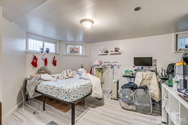 bedroom with light wood-type flooring and radiator heating unit