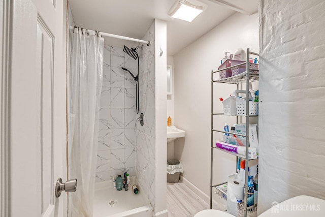 bathroom featuring toilet, wood-type flooring, and walk in shower