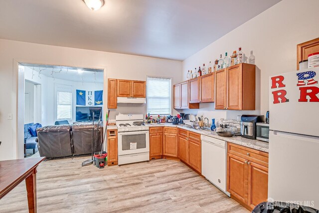 kitchen with white appliances and light hardwood / wood-style flooring