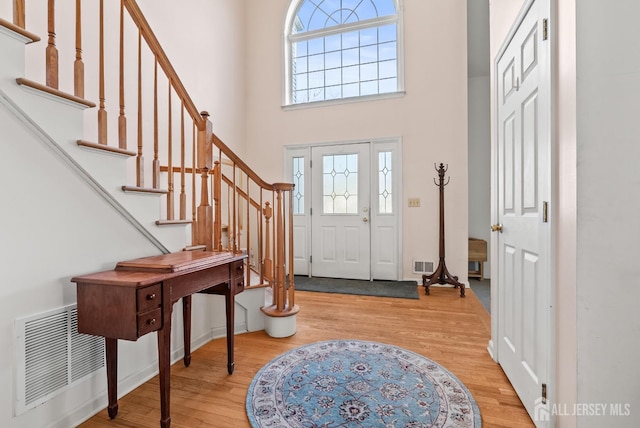 foyer featuring a towering ceiling and light hardwood / wood-style floors