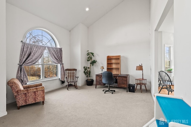 carpeted office with a wealth of natural light and high vaulted ceiling