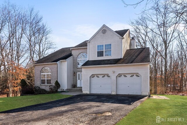 view of property featuring a garage and a front yard