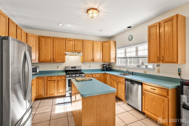 379 Sapphire Dr, Jackson, NJ 08527 - kitchen featuring appliances with stainless steel finishes, under cabinet range hood, a center island, light tile patterned floors, and a sink