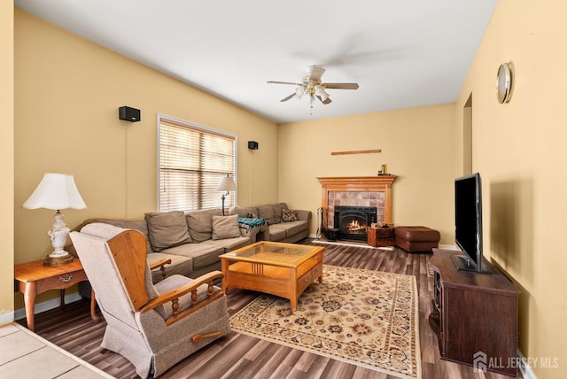 living room with a tile fireplace, hardwood / wood-style floors, and ceiling fan