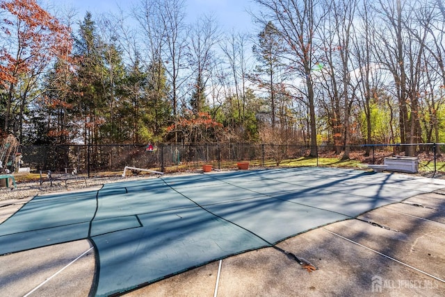 view of swimming pool with tennis court