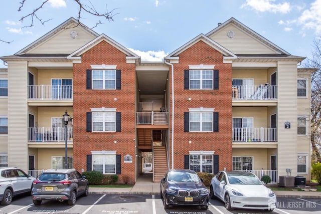 238 Lucy Ct, South Plainfield, NJ 07080 - view of building exterior featuring cooling unit and uncovered parking