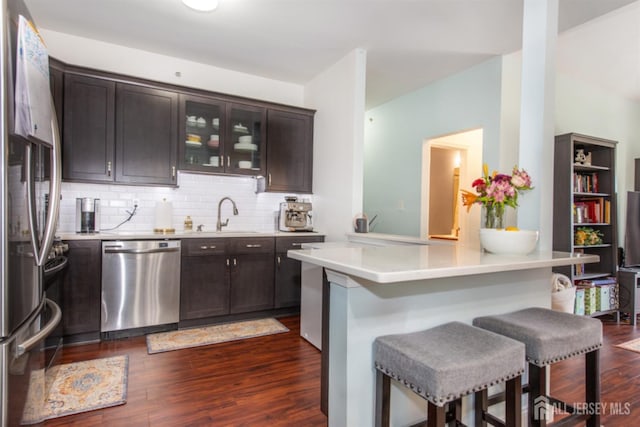 238 Lucy Ct, South Plainfield, NJ 07080 - kitchen featuring a sink, stainless steel appliances, dark wood-style floors, dark brown cabinetry, and a kitchen bar