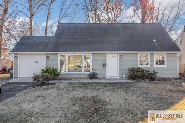 cape cod-style house featuring a garage, driveway, a shingled roof, and a front yard