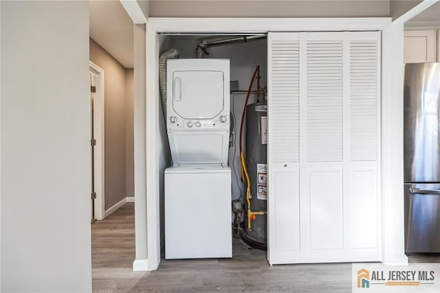 washroom with laundry area, stacked washer / dryer, gas water heater, and wood finished floors