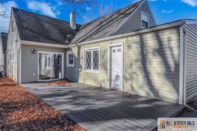 rear view of property featuring cooling unit and a wooden deck