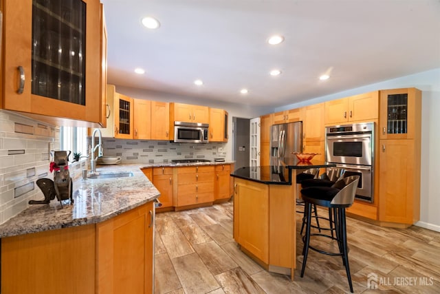 17 Theodore Dr, East Brunswick, NJ 08816 - kitchen with appliances with stainless steel finishes, a kitchen breakfast bar, backsplash, light stone countertops, and light brown cabinets