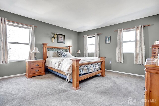 carpeted bedroom featuring multiple windows