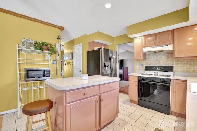 kitchen with a center island, light tile patterned floors, a kitchen breakfast bar, stainless steel appliances, and backsplash