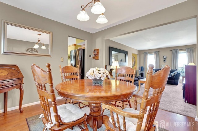 dining area featuring light wood-style floors and baseboards