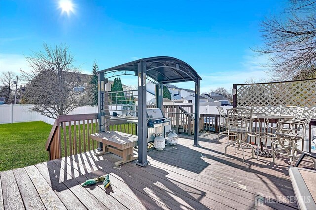 wooden deck featuring a yard and an outdoor bar