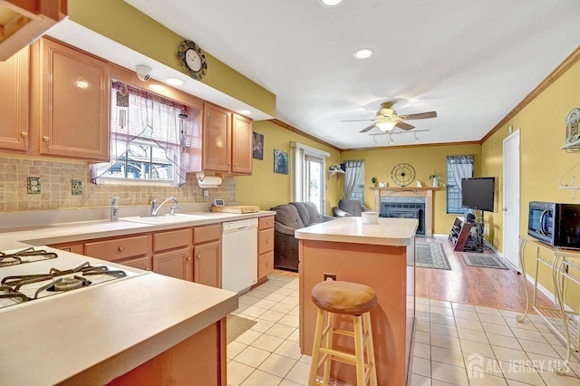 kitchen featuring sink, crown molding, white dishwasher, light tile patterned flooring, and decorative backsplash