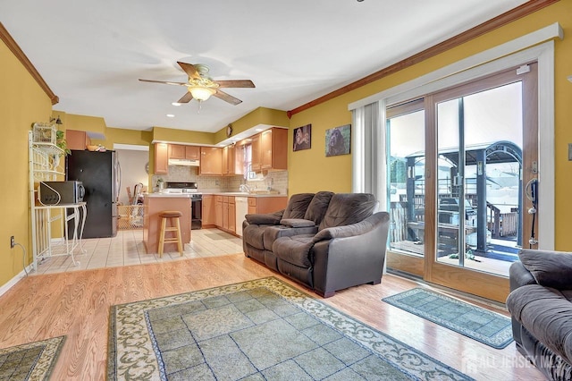 living room featuring crown molding, ceiling fan, and light wood-type flooring