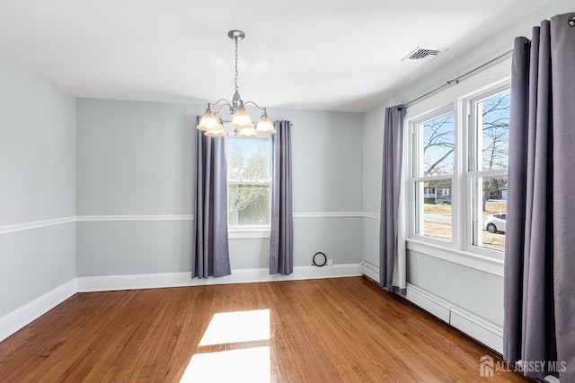 unfurnished dining area with a healthy amount of sunlight, visible vents, and wood finished floors