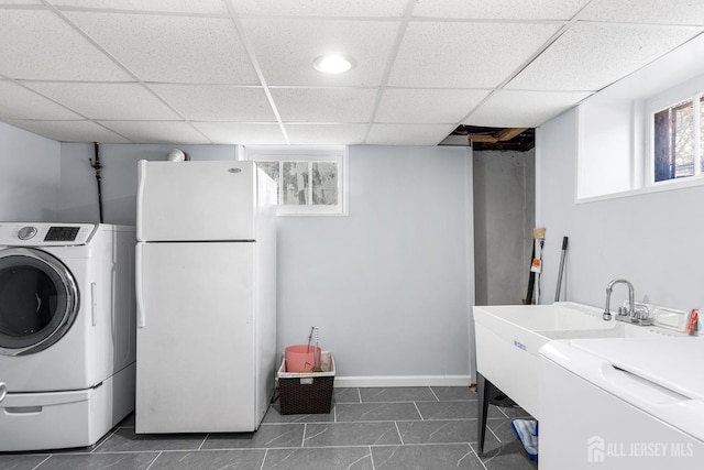 laundry room featuring laundry area, dark tile patterned floors, baseboards, and washer and dryer