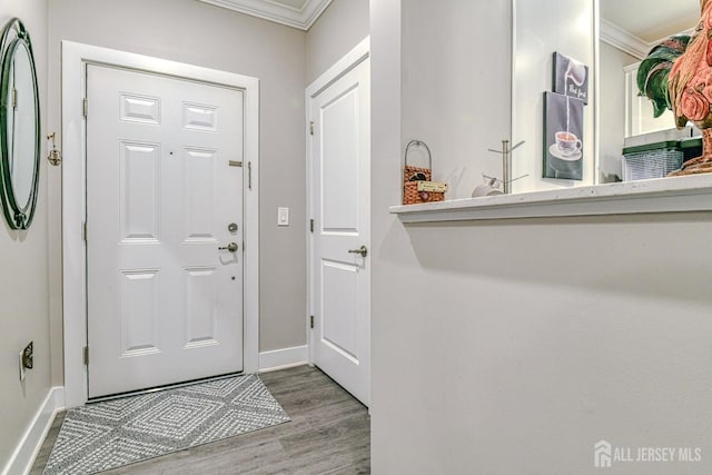 entrance foyer featuring crown molding, wood finished floors, and baseboards