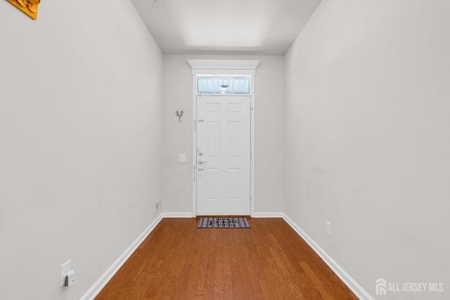 doorway to outside with baseboards and wood finished floors