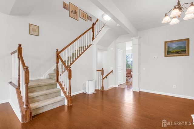 staircase featuring a chandelier, wood finished floors, and baseboards