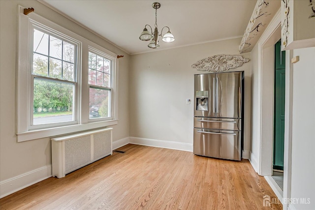 unfurnished room featuring radiator heating unit, light wood-style floors, baseboards, and ornamental molding