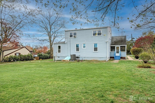 back of house featuring a sunroom, a yard, and central AC unit