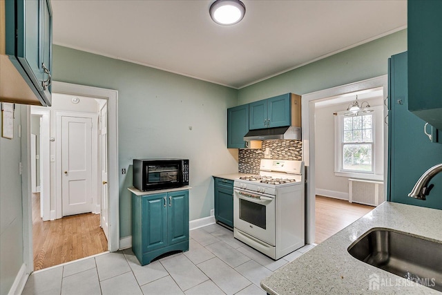 kitchen featuring white gas range oven, a sink, under cabinet range hood, black microwave, and tasteful backsplash