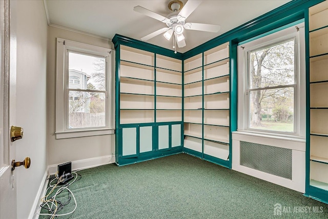 spare room featuring carpet flooring, ornamental molding, baseboards, plenty of natural light, and ceiling fan