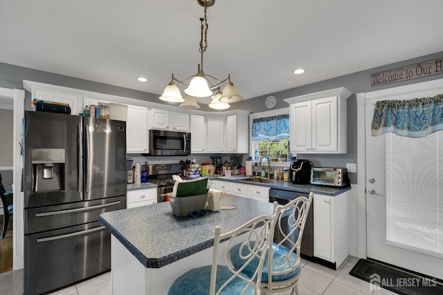 kitchen with white cabinetry, dark countertops, light tile patterned floors, and stainless steel appliances