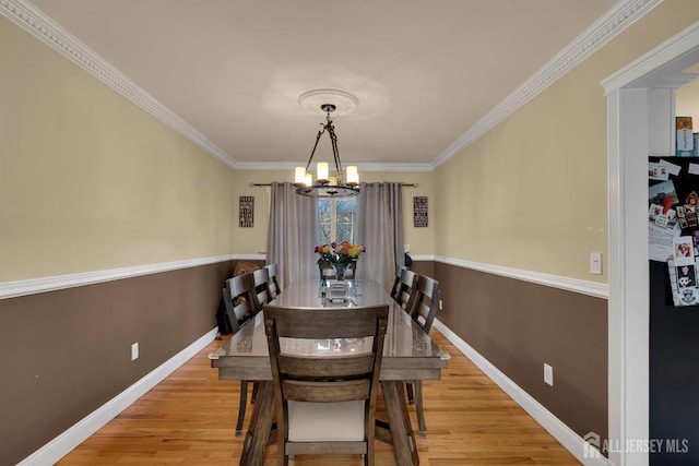 dining area featuring ornamental molding, wood finished floors, baseboards, and a chandelier