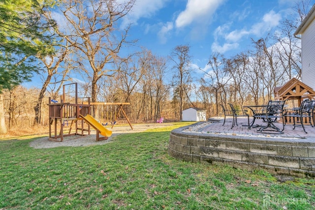 view of yard featuring an outbuilding, a storage shed, and a playground