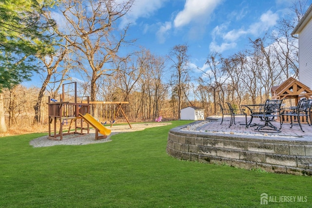 view of yard with an outbuilding, a playground, and a storage unit