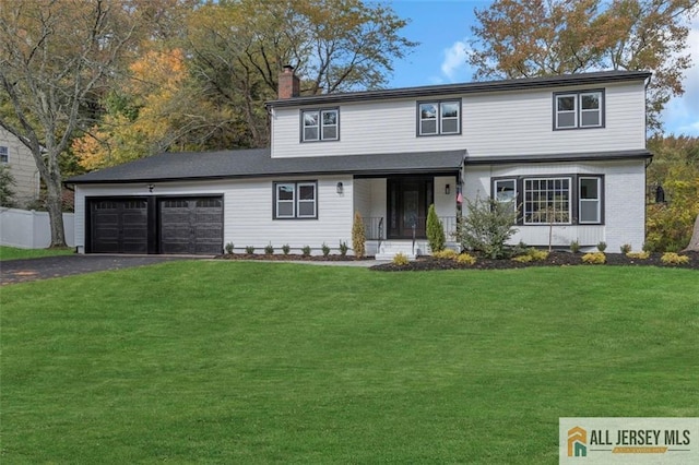 view of property featuring a front lawn and a garage