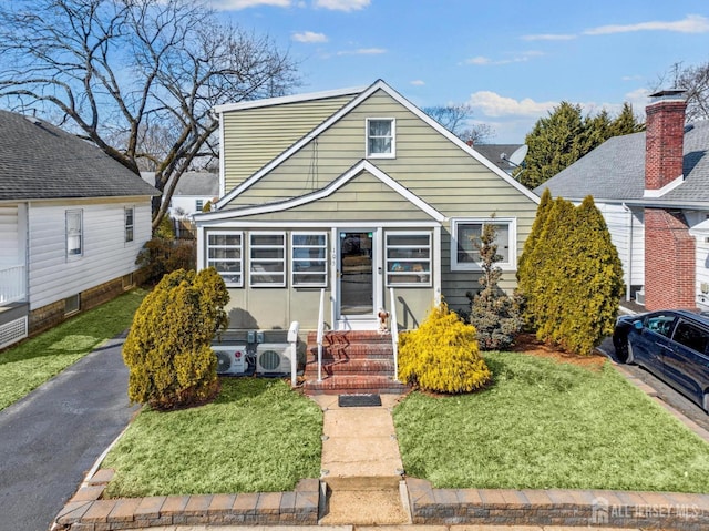 bungalow-style home with entry steps and a front lawn