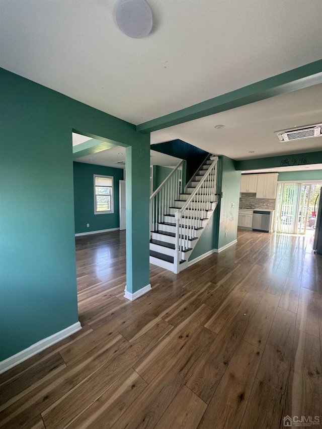 unfurnished living room featuring plenty of natural light and dark wood-type flooring