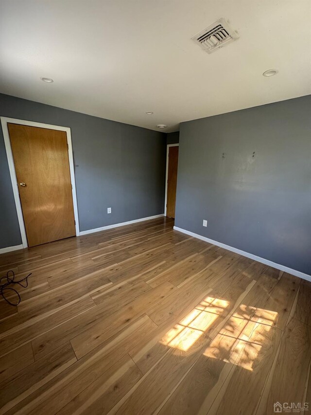 unfurnished room with hardwood / wood-style flooring