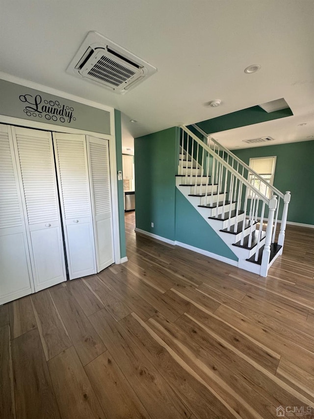 interior space with baseboards, visible vents, and wood finished floors