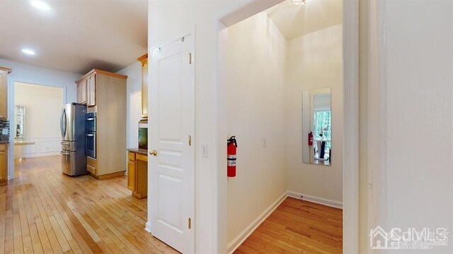 corridor with light hardwood / wood-style flooring