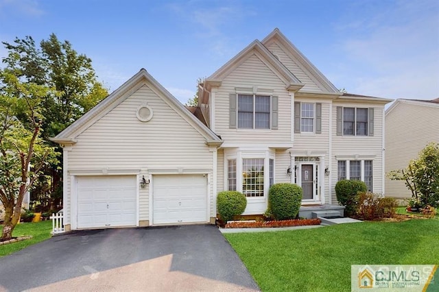 view of front of property featuring a front lawn, a garage, and aphalt driveway