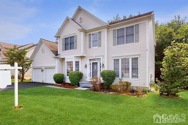 view of front of house with a front yard and a garage