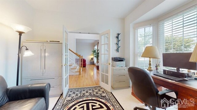 home office with french doors and light hardwood / wood-style flooring