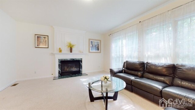 carpeted living room with a high end fireplace