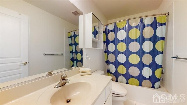 full bathroom featuring shower / bathtub combination with curtain, vanity, and toilet