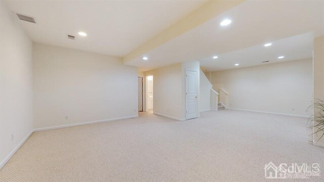 basement featuring light colored carpet